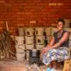 Clean Cookstoves Malawi - A woman cooking lunch whilst the other cookstoves dry in the background