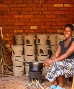 Clean Cookstoves Malawi - A woman cooking lunch whilst the other cookstoves dry in the background