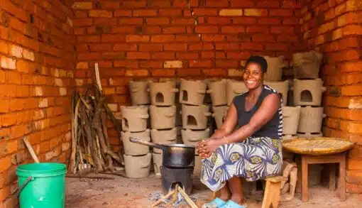 Clean Cookstoves Malawi - A woman cooking lunch whilst the other cookstoves dry in the background